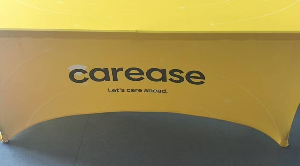 Yellow 180 gsm stretch table cover printed with a client logo on a 6 ft trestle table