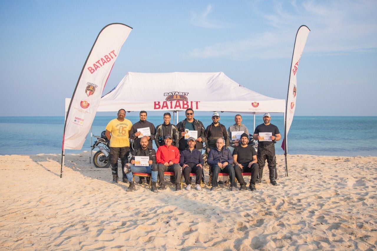Beach flag banners flanking a branded tent at an outdoor beach event