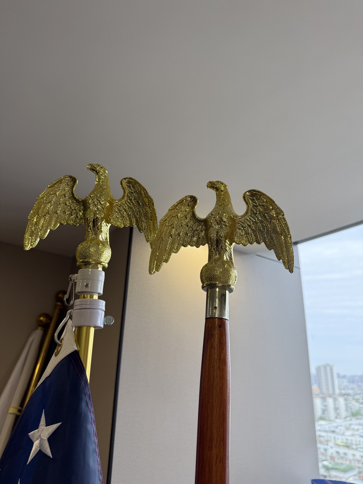 Eagle head finial in gold plated metal on a metal flagpole and on a wooden indoor flagpole