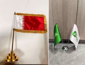 Satin table flag with gold fringe on a gold plated base, and a double pole desktop flag stand with custom double-sided printed flags
