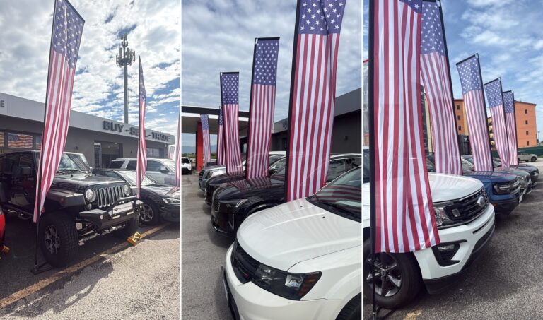 US flag display sets on 4.3 metre poles in front of vehicles on a car dealership lot